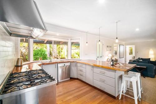 a kitchen with a stove top oven next to a living room at 'The Love Shack' Pet-Friendly Beach Bungalow in Prevelly
