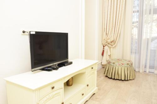 TV en un armario blanco en la sala de estar en Hotel Menshikov, en Odessa