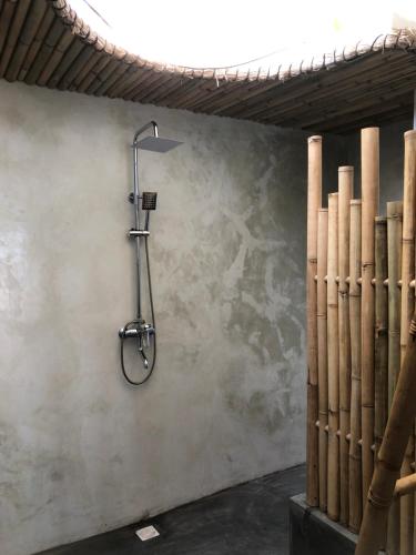 a shower in a room with a wall at La Bohème in Gili Air