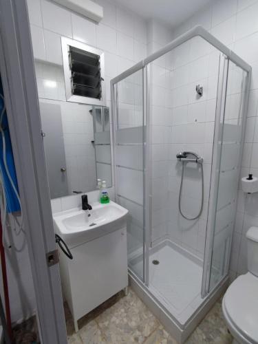 een witte badkamer met een douche en een wastafel bij VG UN POQUITO DE TI in El Puerto de Santa María