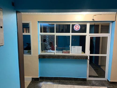 a restaurant with a blue wall and a counter at Kibodya Hotel Nkrumah in Dar es Salaam
