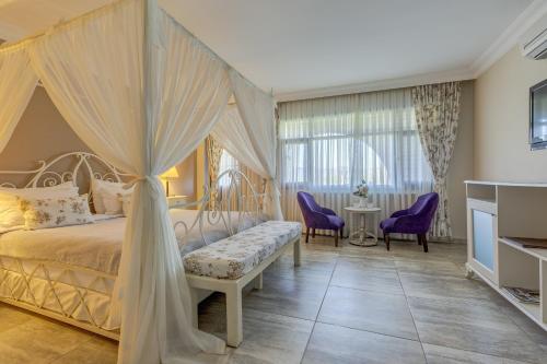 a bedroom with a canopy bed and purple chairs at Agva Greenline Guesthouse (Adult Only +12) in Agva