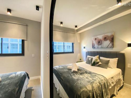een slaapkamer met een bed en 2 ramen bij Paradise Frei Caneca in Sao Paulo