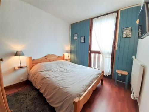 een slaapkamer met een groot bed en een raam bij Appartement Saint-Lary-Soulan, 3 pièces, 6 personnes - FR-1-457-309 in Saint-Lary-Soulan