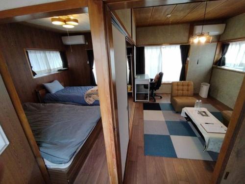 石巻市にある民家の一室2 Private Room in Japanese Vintage House with 2 Beds, Free Parking Good to Travel for Tashiro Cats Islandのベッドとリビングルームが備わる小さな客室です。