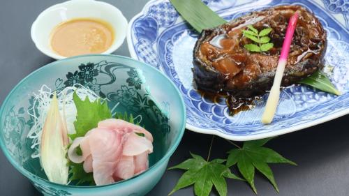 two blue and white plates with food on a table at Baigetsu Ryokan in Shimo-suwa