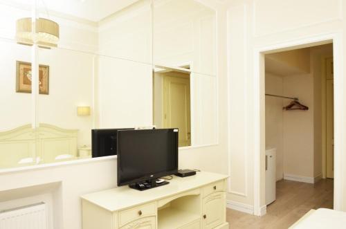 a living room with a tv and a mirror at Hotel Menshikov in Odesa