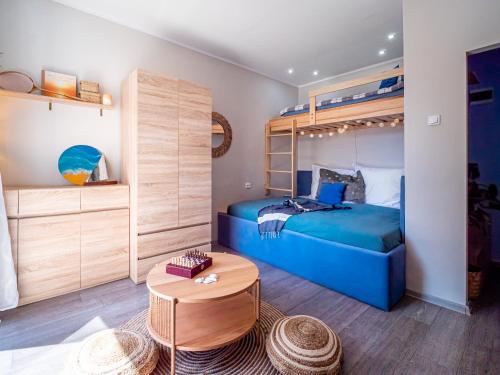 1 dormitorio con 1 cama azul y literas en Apartament The Middle One (Train Station - 500m, The Beach - 900 m) en Gdynia