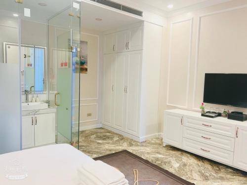 Phúc YênにあるL'ama Villa Đại Lải - Venuestayの白いバスルーム(シャワー付)、テレビが備わります。
