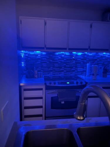 a kitchen with blue lights on the counters at The Vue at Dos Marina in Fajardo