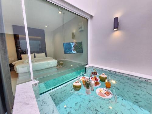 una habitación de hotel con una piscina con comida y una cama en PVILLA, en Ban Phraek Sa