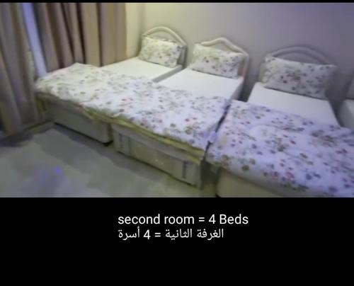 two beds sitting next to each other in a room at مجمع الحديقة in Salalah