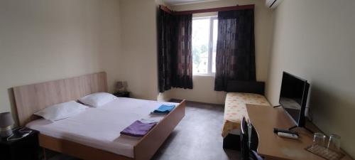 1 dormitorio con 1 cama y escritorio con ordenador en East Gate Guest Rooms, en Plovdiv