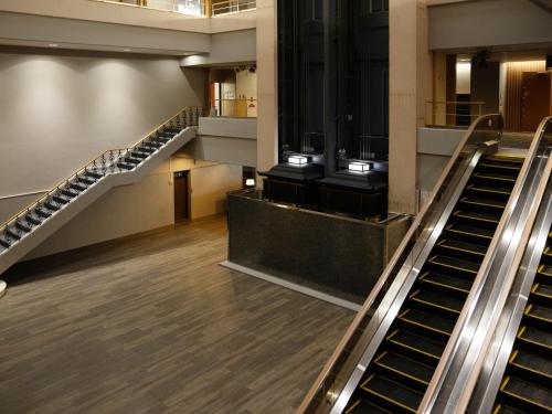 an escalator in a building with a staircase at Hotel Sakura Ureshino in Ureshino