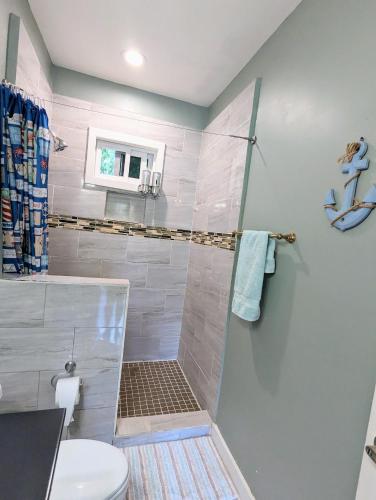 a bathroom with a shower and a toilet at West Bay Roatan - Sunny & Modern Oasis- - 3 min to beach - Queen beds! in Roatán