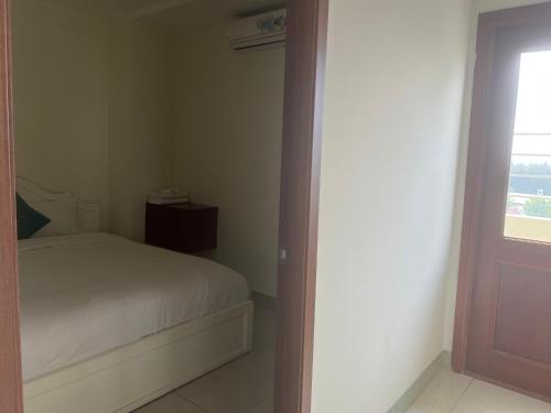 a small bedroom with a bed and a window at Thành Vinh Hotel & Apartment in Ho Chi Minh City