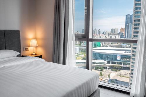 a bedroom with a bed and a large window at Haeundae Centum Hotel in Busan