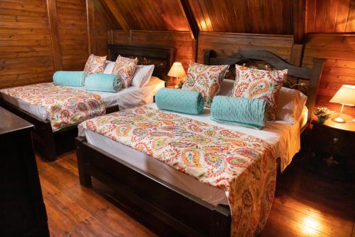 two beds in a room with wooden walls and wood floors at Finca Villarreal in Cali