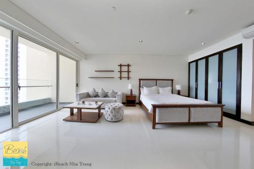 a white bedroom with a bed and a couch at Studio With SeaView in Nha Trang