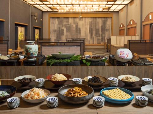 a buffet with bowls of food on a table at Hotel Sakura Ureshino in Ureshino