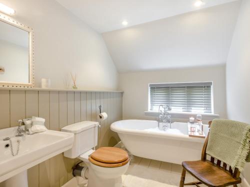 a bathroom with a tub and a toilet and a sink at Hope Cottage in Ilketshall Saint Andrew