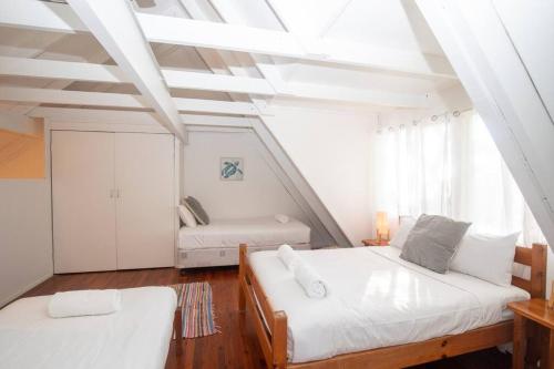 a attic room with two beds and a window at 20 Yarrong Road Close to Cylinder Beach in Point Lookout