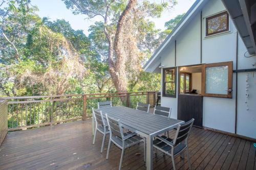 a wooden deck with a table and chairs on it at 20 Yarrong Road Close to Cylinder Beach in Point Lookout