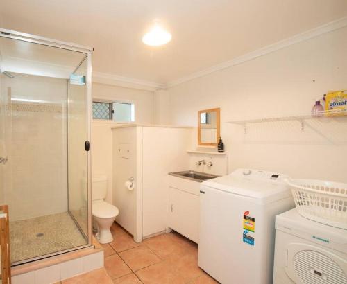a bathroom with a shower and a toilet and a sink at 20 Yarrong Road Close to Cylinder Beach in Point Lookout