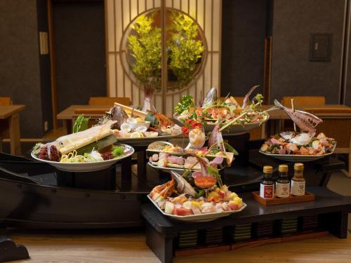 a buffet with several plates of food on a table at Hotel Sakura Ureshino in Ureshino