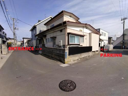 a house on a street with a manhole at 民家の一室1 Private Room in Japanese Vintage House with Tatami, Single Bed, Free Parking, Good to Travel for Tashiro Cats Island in Ishinomaki