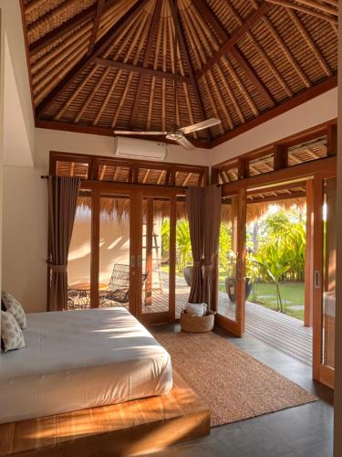 a bedroom with a bed and a wooden ceiling at La Reserva Villas Bali in Jimbaran