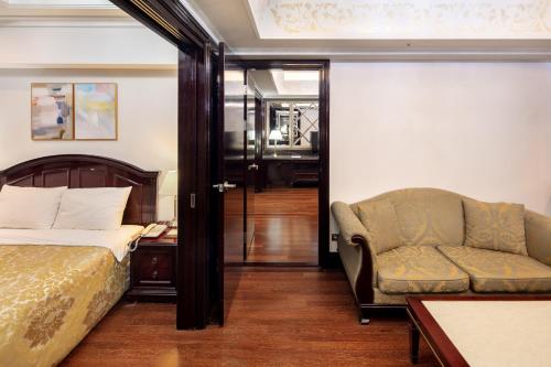 a bedroom with a bed and a couch and a chair at Gangnam Artnouveau City in Seoul