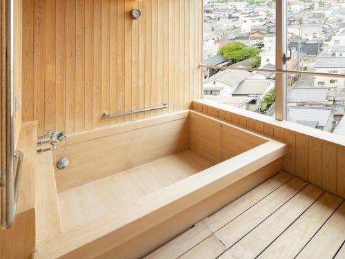 a bath tub in a bathroom with a window at Hotel Sakura Ureshino in Ureshino