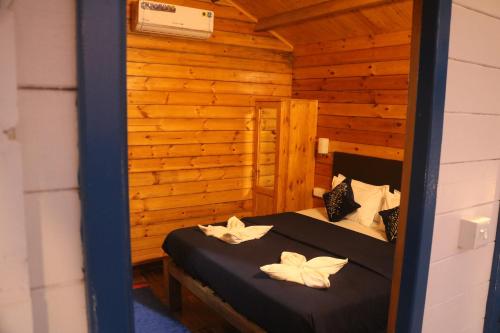 um quarto com 2 camas num chalé de madeira em Agonda island view em Agonda