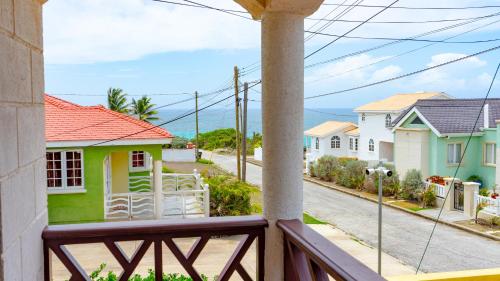 einen Balkon mit Blick auf eine Straße mit Häusern in der Unterkunft Da-Vis By The Ocean in Saint Philip