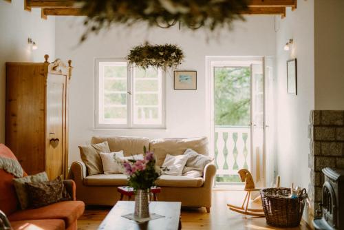 a living room with a couch and two windows at Willa Tyrolczyk in Karpacz