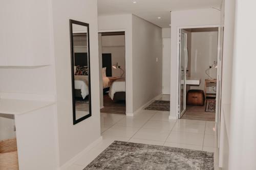 a hallway with mirrors and a room with a bed at View @ The Bay Apartments 9 in Mossel Bay