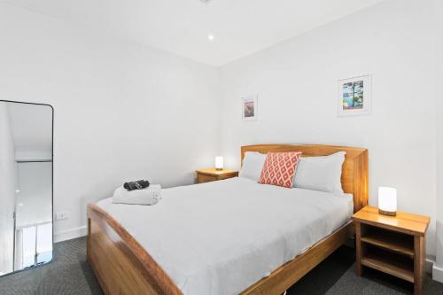 a bedroom with a bed and two night stands at Belle Escapes - Getaway on Colley in Glenelg
