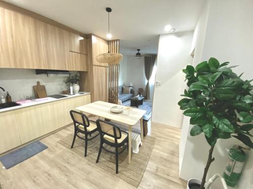 a kitchen and dining room with a table and a plant at NUVALI Amaia Steps Parkway 2 BR Condo THE SANCTUARY with pool, free parking near Carmelray Industrial Park, Ayala Solenad, Xavier School in Pitland