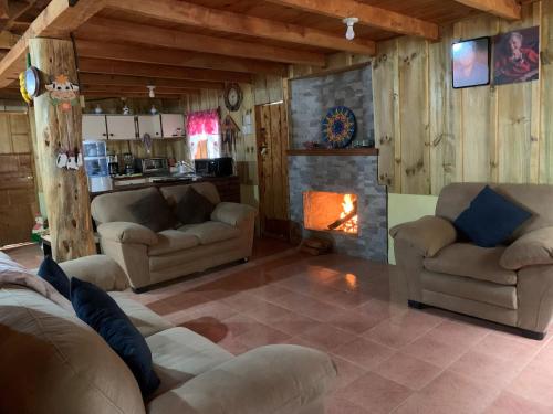 a living room with two couches and a fireplace at Cabaña Mamá Elia in Trinidad