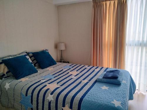 a bedroom with a blue and white bed with blue pillows at Habitación con baño privado y desayuno incluído en casa de familia in Lima