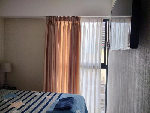 a bedroom with a bed and a large window at Habitación con baño privado desayuno incluído en casa de familia in Lima