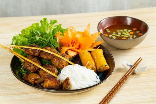 a plate of food with meat and vegetables and a bowl of soup at The Oriental Jade Hotel in Hanoi
