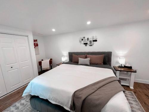 1 dormitorio con 1 cama grande y pared blanca en The Victoria Suite in Elora- King Bed, en Elora