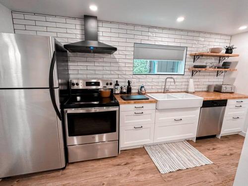 una cucina con frigorifero in acciaio inossidabile e lavandino di The Victoria Suite in Elora- King Bed a Elora