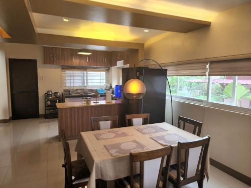 a kitchen and dining room with a table and chairs at Serenity Home near Ayala Malls Serin in Tagaytay