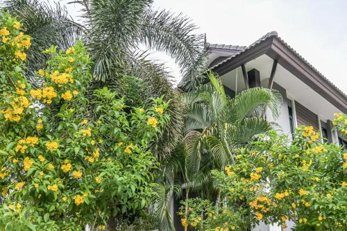 a house with palm trees in front of it at Baan Kieng Tawan in Khong Chiam