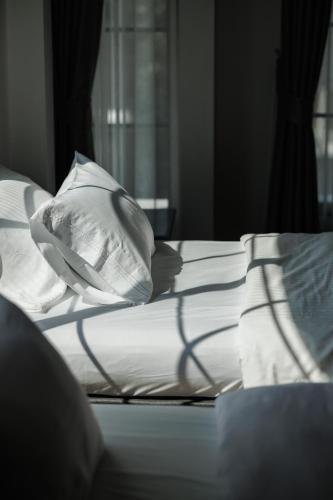 a bed with white sheets and pillows on it at Casa Luna in Bangkok