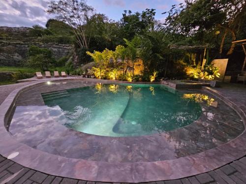 a swimming pool with a patio and lights in a backyard at Tuku, in Guarinocito