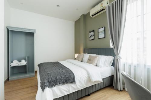 a bedroom with a large bed and a window at Casa Luna in Bangkok